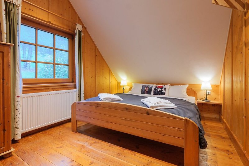 Komfortables Schlafzimmer mit Holzmöbeln und gemütlicher Beleuchtung.