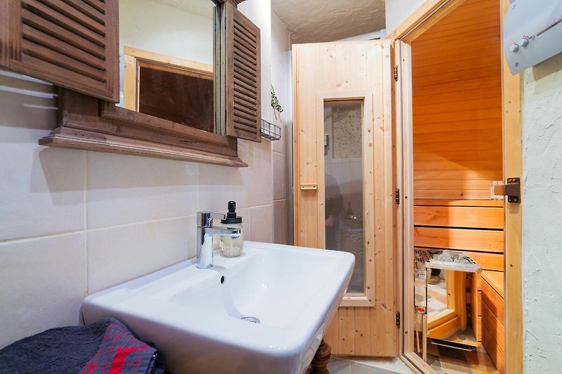 Schönes Badezimmer mit braunem Holz, Spiegel und Fliesen.