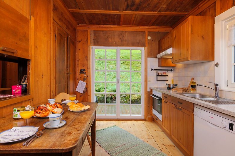 Moderne Küche mit Holzmöbeln, Arbeitsplatte und Fenster.