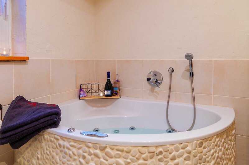 Schönes Badezimmer mit brauner Badewanne, Pflanze und Fliesen.
