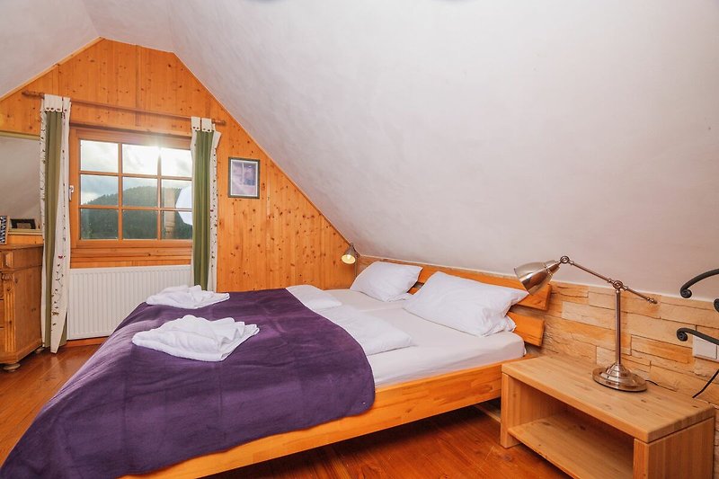 Gemütliches Schlafzimmer mit Holzmöbeln und Bettwäsche in Orange.