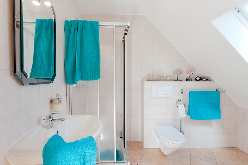 Ein modernes Badezimmer mit lila Akzenten und blauen Fliesen.