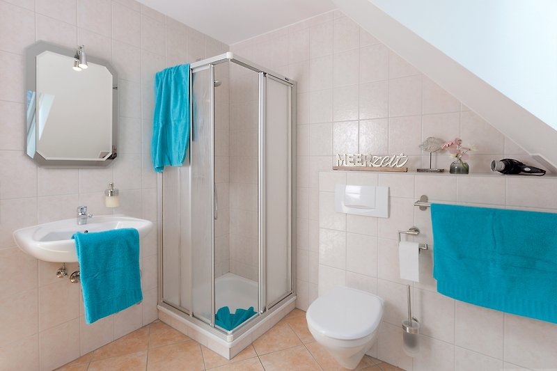 Schönes Badezimmer mit lila und blauen Fliesen, Waschbecken und Toilette.