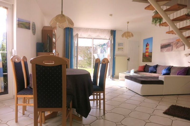 Wohnzimmer mit Sitzgarniur, Esstisch, Terrassenflügel und Durchgang zum Abstellraum 