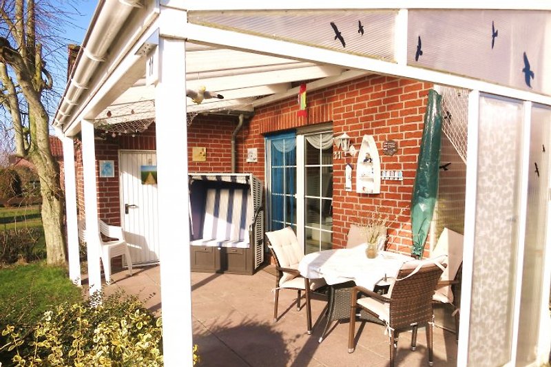 Überdachte Terrasse mit Strandkorb und Sitzgruppe 