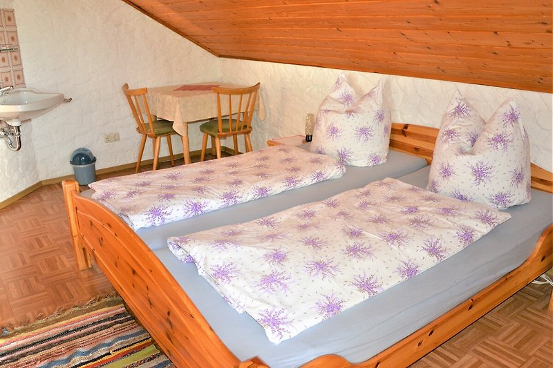 Holz, Textilien, Komfort: Schlafzimmer mit Bett, Kissen, Holzmöbeln.