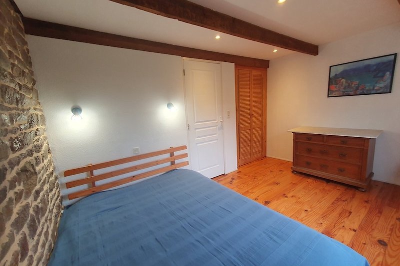 Gemütliches Schlafzimmer mit Holzmöbeln und Holzparkett für 2 Personen