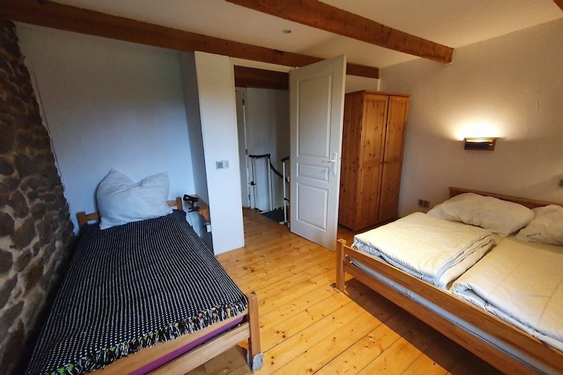 Gemütliches Schlafzimmer mit Holzparkett für 3 Personen