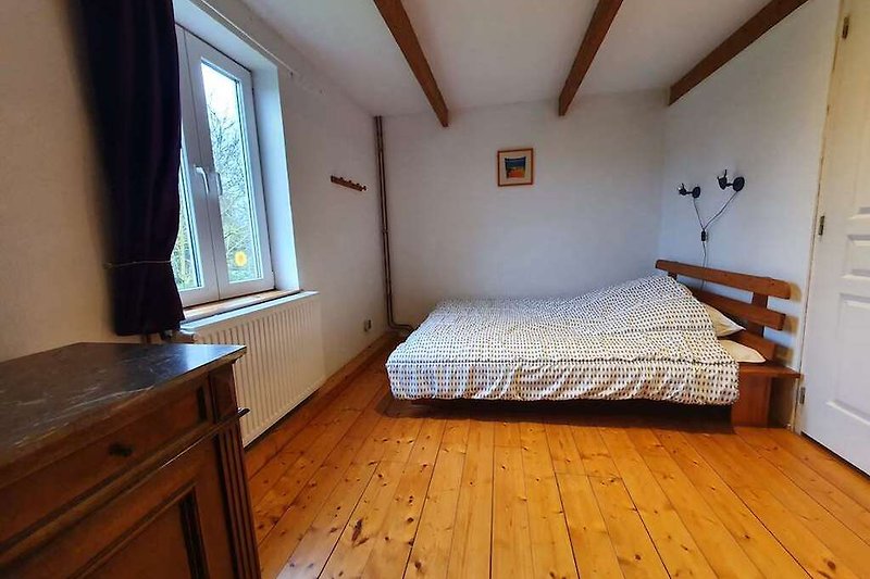 Gemütliches Schlafzimmer mit Holzmöbeln und Holzparkett für 2 Personen