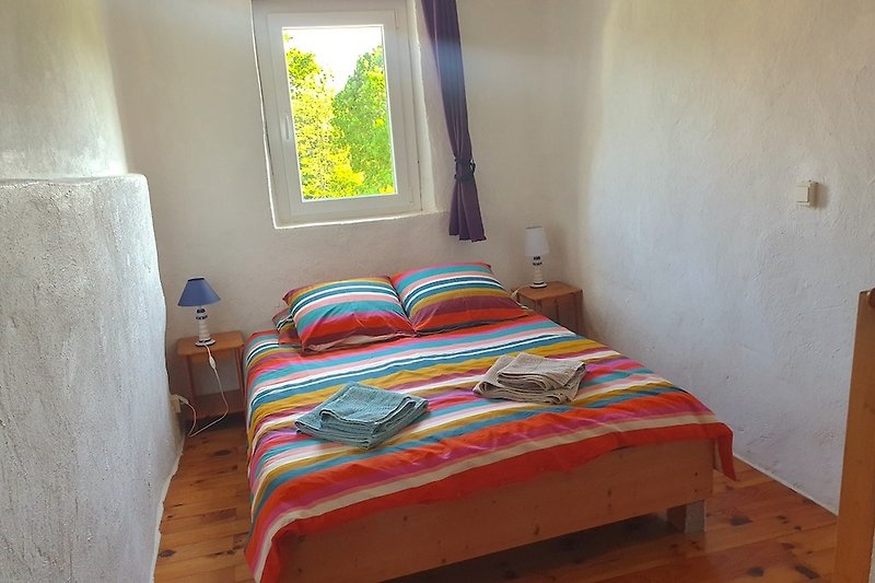 Malve: Gemütliches Schlafzimmer mit Holzparkett