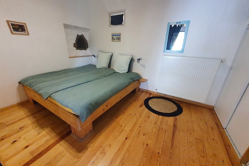 Gemütliches Schlafzimmer mit Kingsize Bett, Holzparkett und Wandschrank