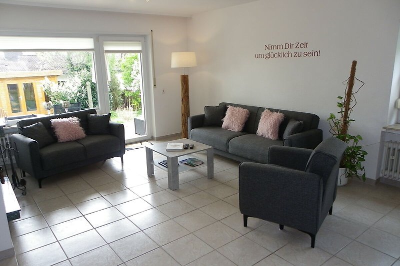 Stilvolles Wohnzimmer mit bequemer Couch mit Zugang zum Garten