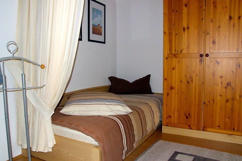 Schlafzimmer mit Holzmöbeln und bequemem 3.Bett.