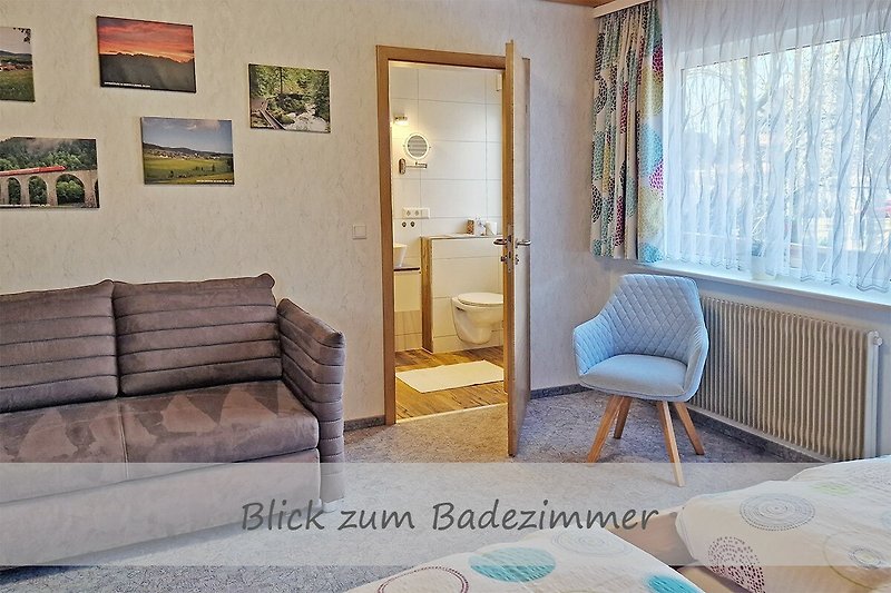 Ferienwohnung Heimatglück - Schlafzimmer mit Blick zum modernen Badezimmer