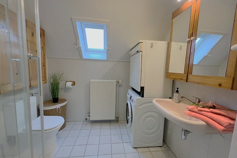 Schönes Badezimmer mit lila Akzenten, Spiegel und Waschbecken.