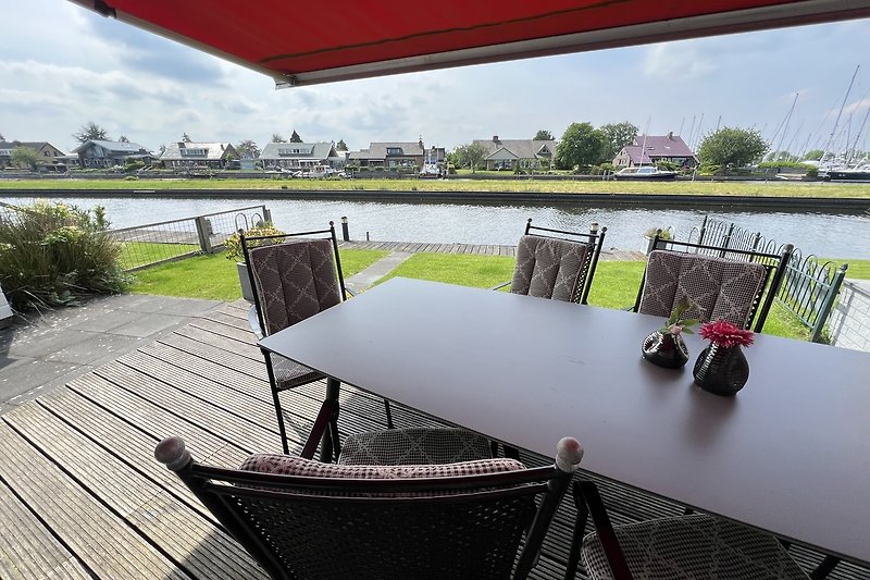 Ferienhaus am Wasser mit sonnige Terrasse und Bootssteg am Haus.