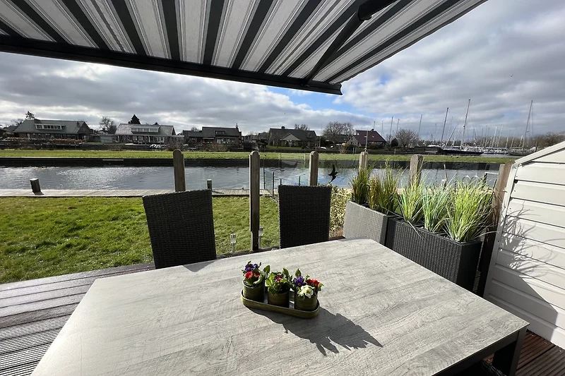 Knusse terras met tuinmeubelen en windscherm.