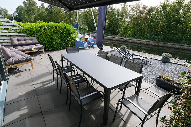 Moderne Terrasse mit Outdoor-Möbeln und Pflanzen.