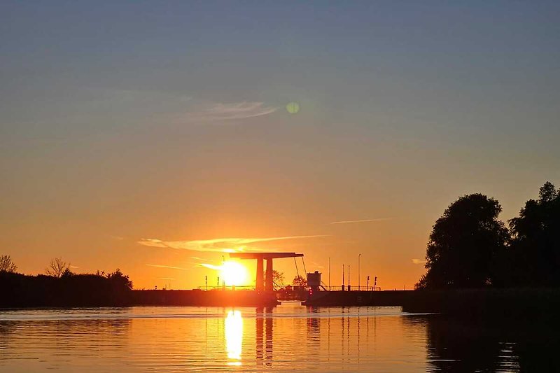 Genießen Sie den atemberaubenden Sonnenuntergang über dem ruhigen See.