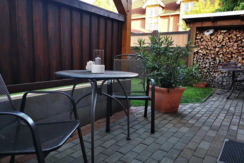 Terrasse mit Gartenmöbeln und Pflanzen.