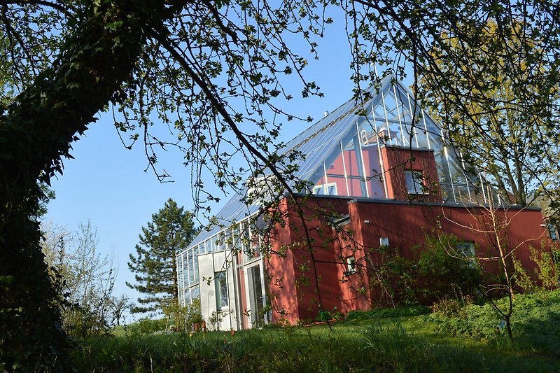 Rustikales Cottage mit grünem Dach in ländlicher Umgebung.