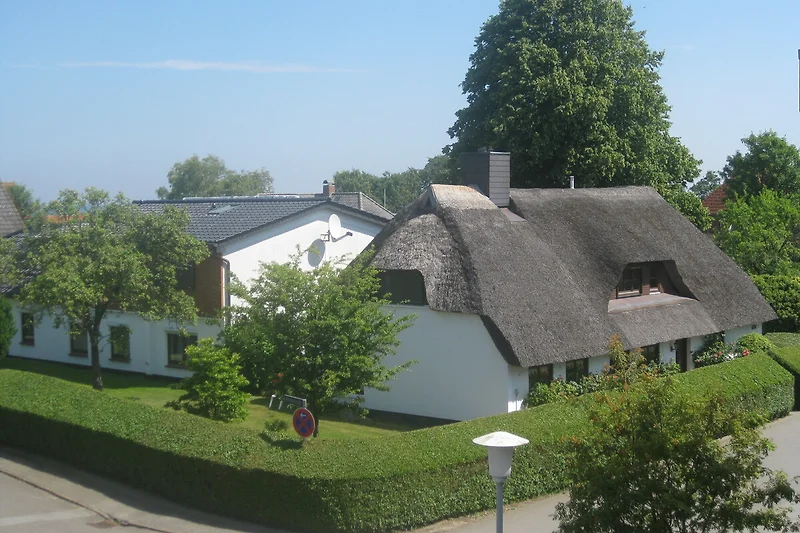 Großer Garten mit gepflegtem Rasen, Hecke und traditionellem Reetdachhaus.
Ferienwohnung "Strandlöper" im Nebengebäude