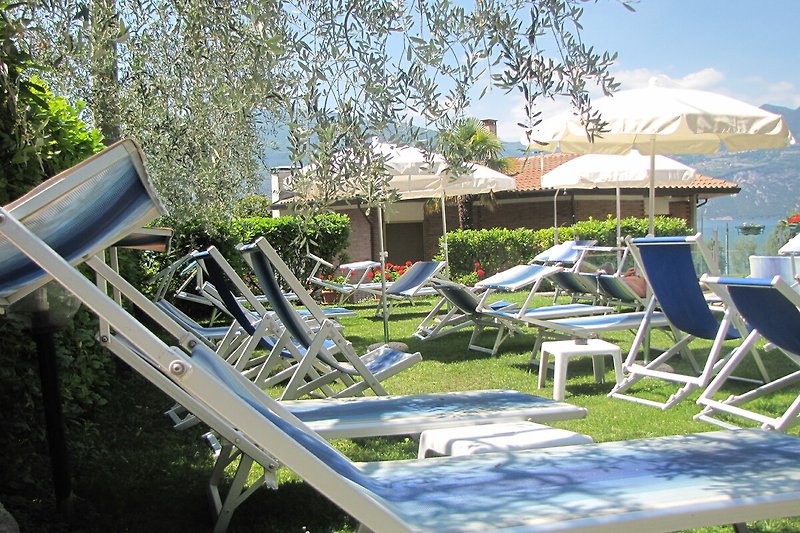 Schwimmbad und Sonnenliege in einem Resort mit Blick auf das Meer.