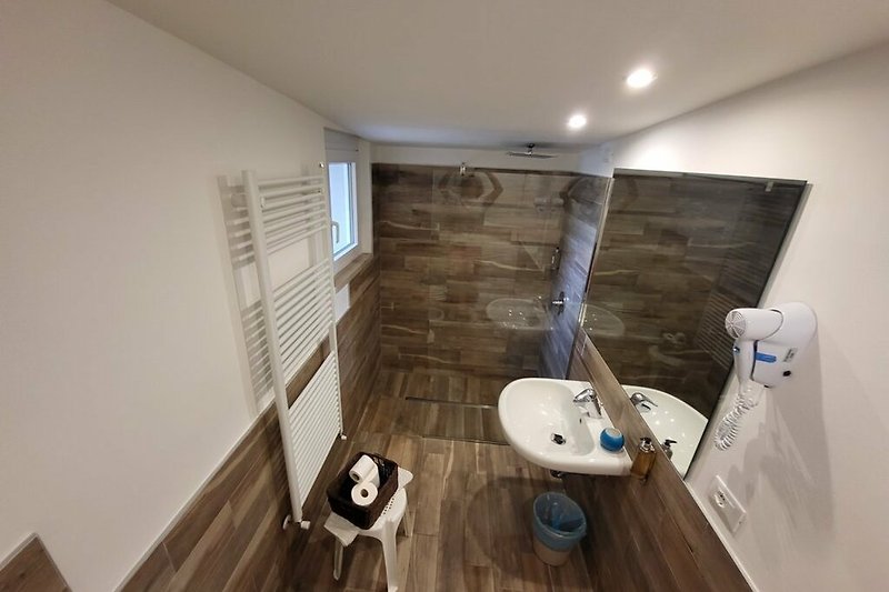 Schönes Badezimmer mit Holzboden und stilvoller Armatur. Perfekt zum Entspannen.