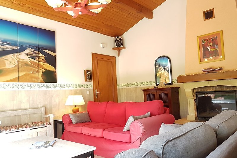 Un salon confortable avec un canapé-lit, une table basse en bois et un éclairage chaleureux.