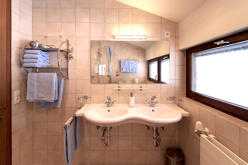 Schönes Badezimmer mit Spiegel, Wasserhahn und Waschbecken.