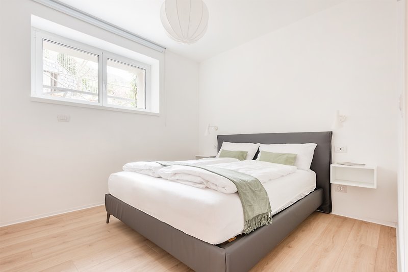Una camera da letto confortevole con arredamento in legno e una finestra luminosa.