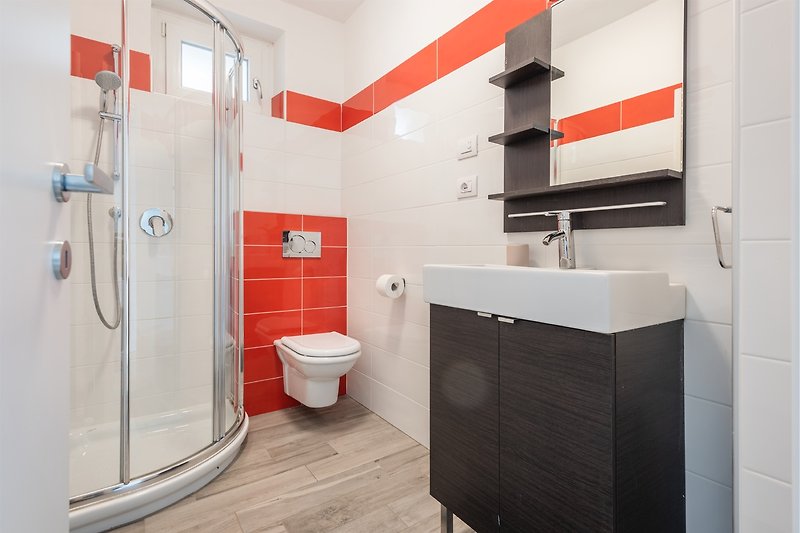 Una stanza da bagno moderna con una doccia spaziosa e una finestra luminosa.