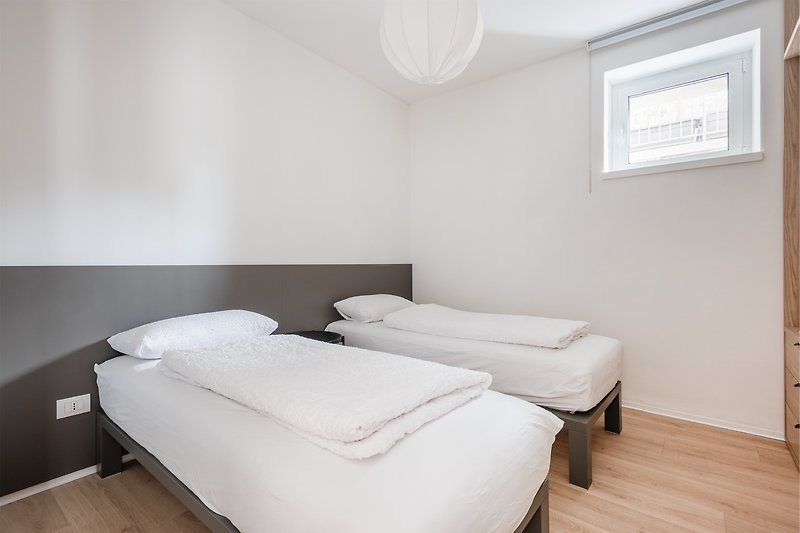 Una camera da letto accogliente con arredamento in legno e finestra luminosa.