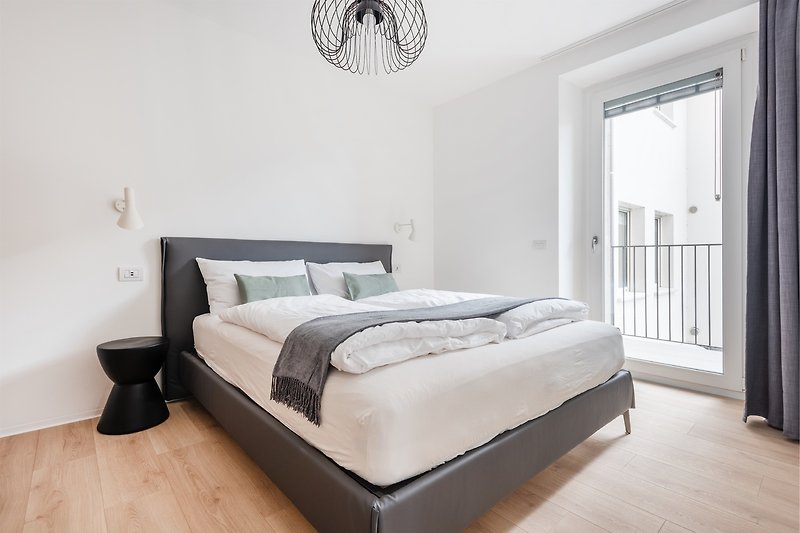 Una camera da letto confortevole con arredamento in legno e una luce naturale.