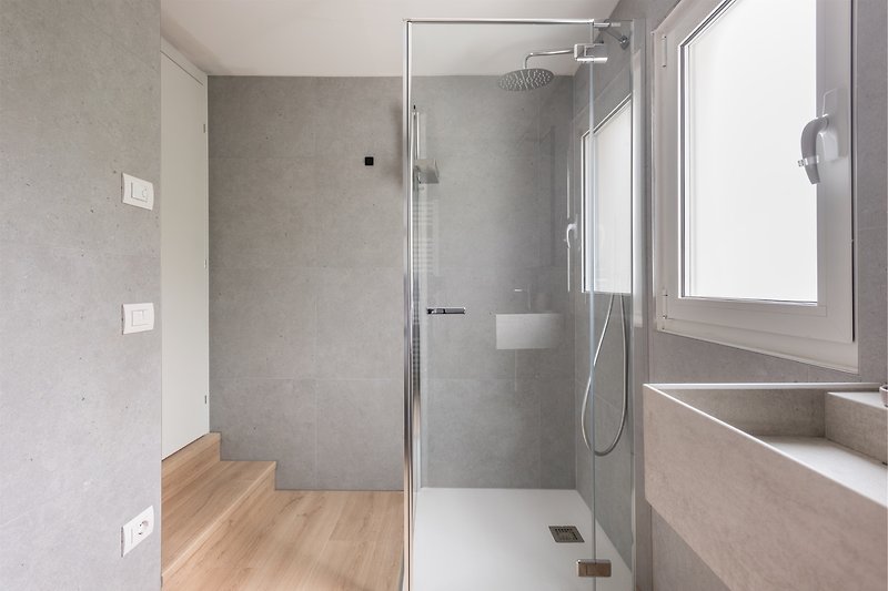 Un bagno moderno con specchio, lavabo e pavimento in legno.