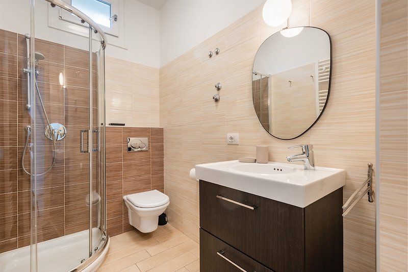 Un bagno moderno con specchio, lavabo e mobili in legno.