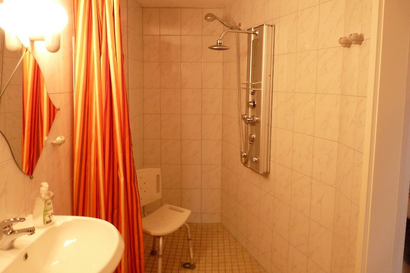 Bad mit befahrbarer Dusche, Waschtisch und erhöhtem WC