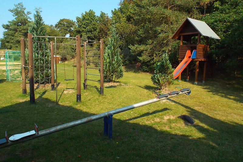 Kinderspeelplaats nr. 1 met glijbaan, schommel, wip en klimrek.
