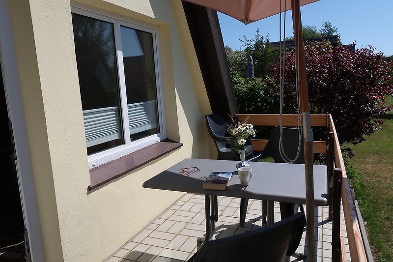 Auf der Terrasse gibt es einen Tisch mit 4 Stühlen und einen Sonnenschirm