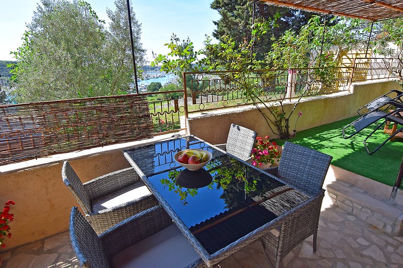 Garten mit Tisch, Stühlen und Pflanzen. Entspannung im Freien.