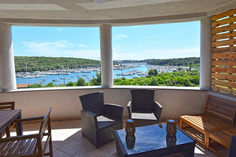 Balkon mit Meerblick, Outdoor-Möbeln und entspannter Atmosphäre.