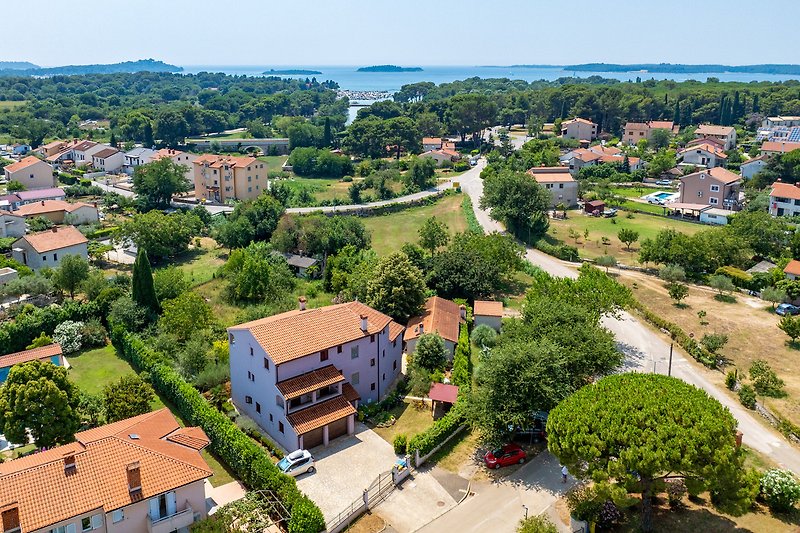 Panoramablick auf Haus, Garten und umliegende Landschaft.