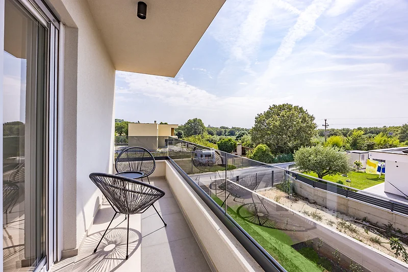Moderne Wohnung mit Balkon, Glasgeländer und Stadtblick.