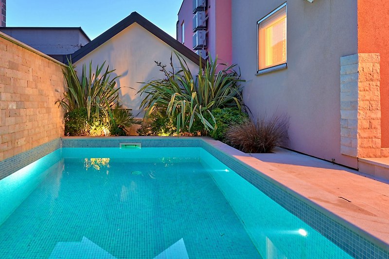 Schönes Ferienhaus mit Pool, Garten und Blick auf das azurblaue Wasser.