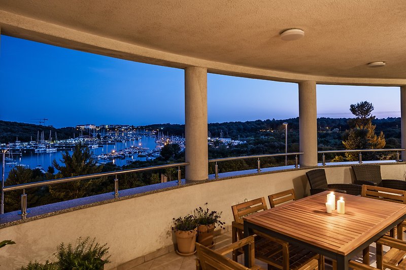 Balkon mit Holzmöbeln und Blick auf die grüne Landschaft.