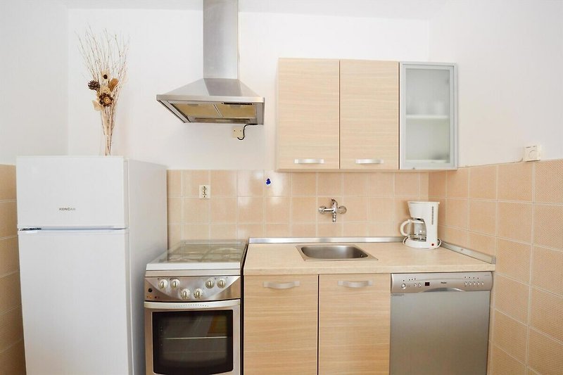 Moderne Küche mit Holzschrank, Gasofen und Spülbecken.