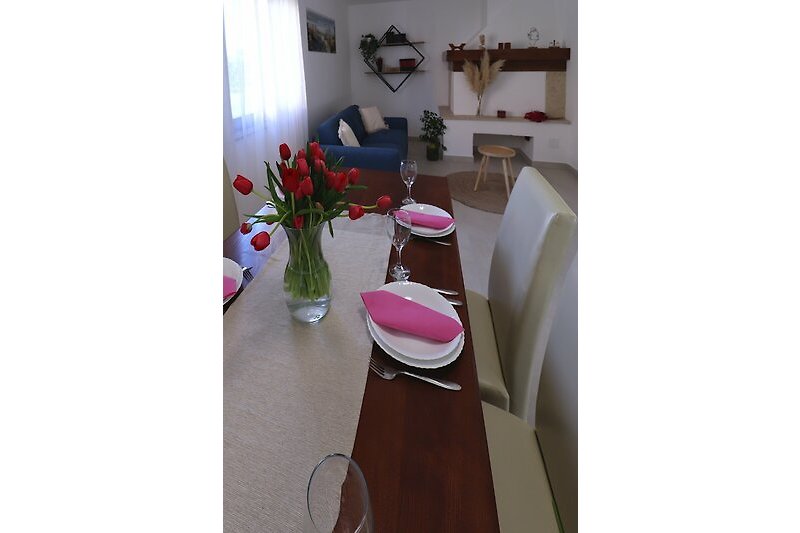 Ein stilvoll eingerichteter Wohnraum mit Blumendekoration und gemütlichen Möbeln.