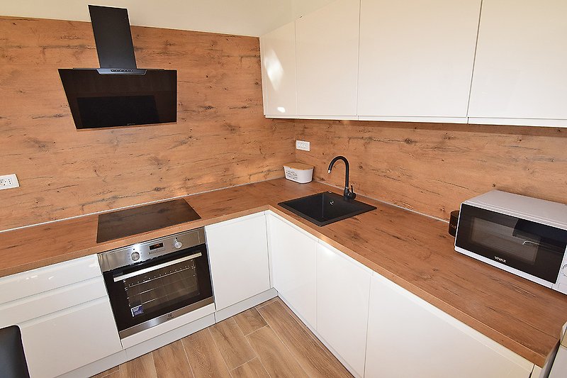 Moderne Küche mit Holzakzenten, Granit-Arbeitsplatte und Edelstahlgeräten.