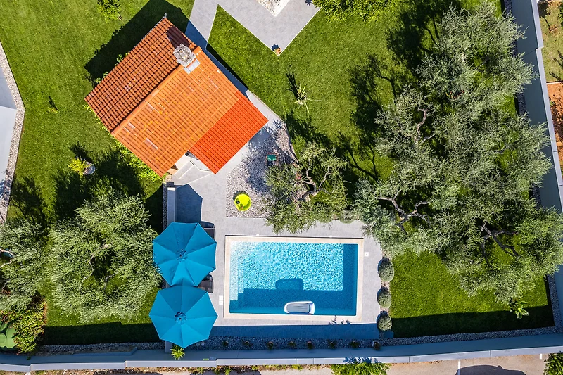 Villa mit Pool, Garten, Sonnenliegen und Outdoor-Möbeln.