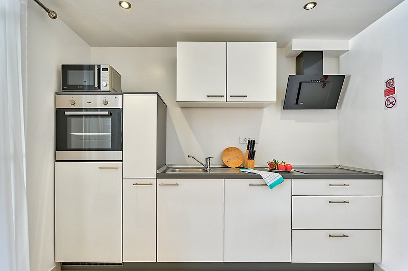 Moderne Küche mit hochwertigen Geräten und stilvollem Design.